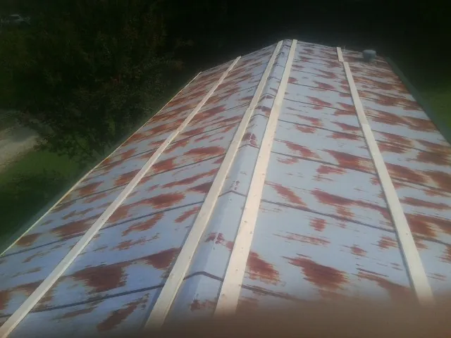 Rusted metal roof panels with new wood purlins before replacement — Storm Damage Roof Repair in Viborg by Roofing Brothers