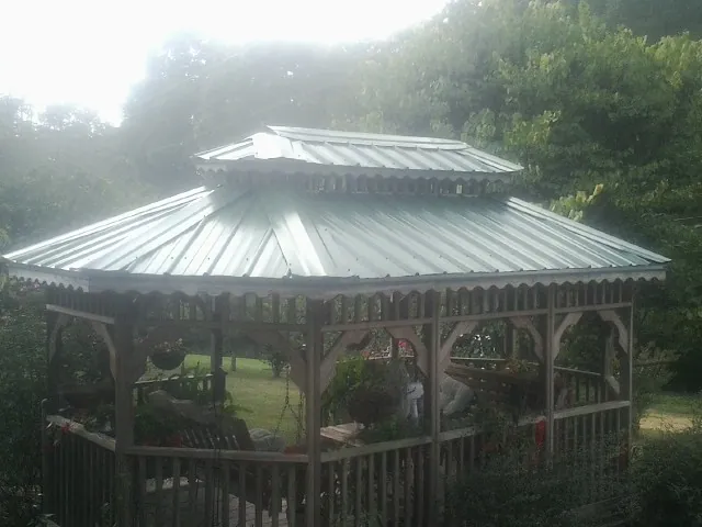 Two tier green metal roof on a garden gazebo in Viborg