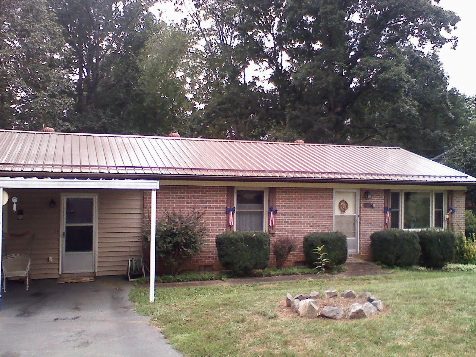 Bronze metal roof and carport on a brick ranch home — Roof Repair work by our crew in Viborg
